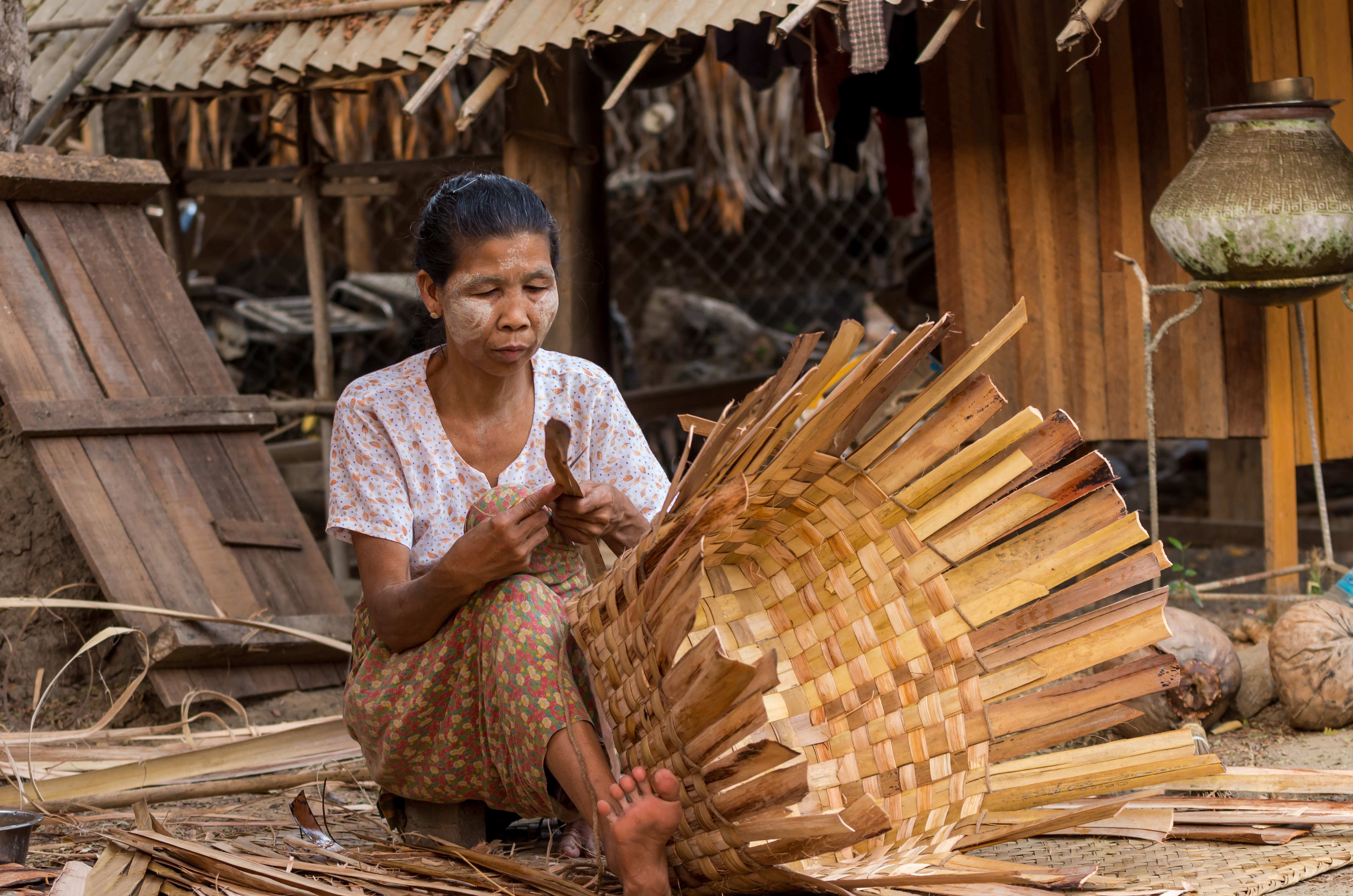 Burmese woman is sorting bamboo to make bamboo wall within village nearly Ubein Bridge,