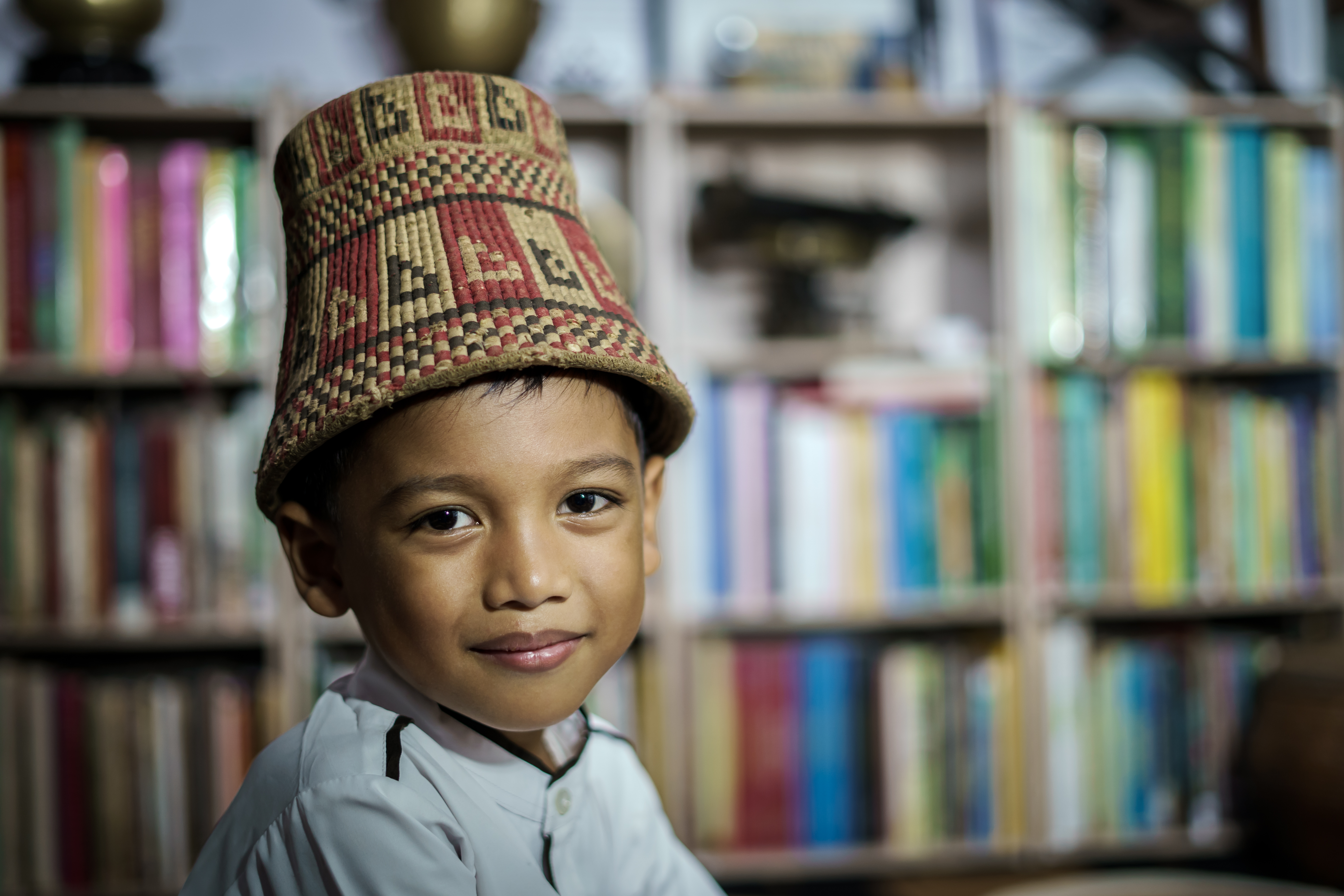 Smiling Asian boy wearing traditional skullcap of Aceh, Indonesia