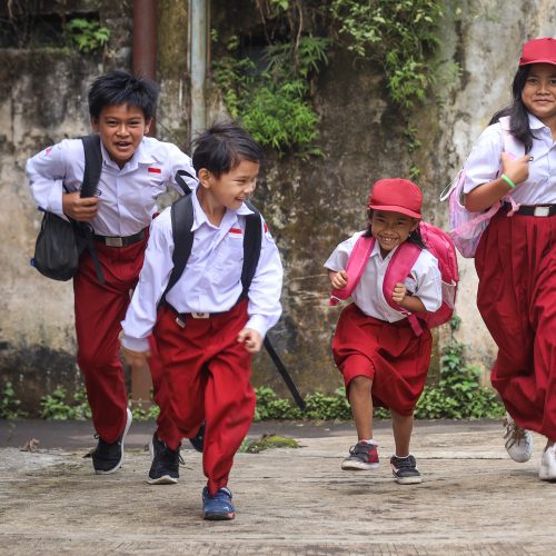 Excited Indonesian primary school kids running cheerful