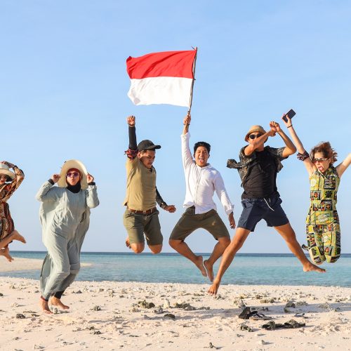 Group of people jumping together on the beach for celebrating Indonesia Independence day